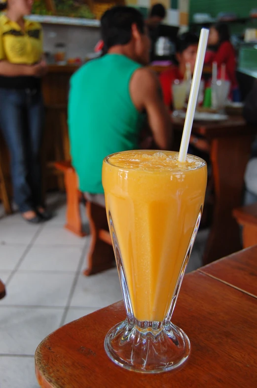 an orange drink is in a glass on the table