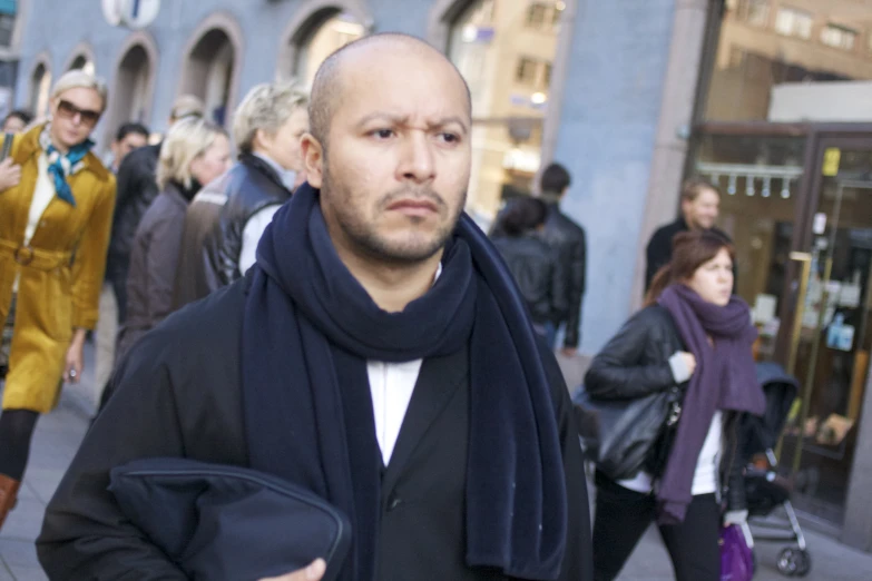 a man is holding his purse while on a crowded street