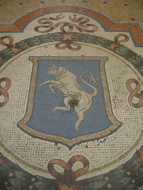 a mosaic tile floor with a stylized lion emblem