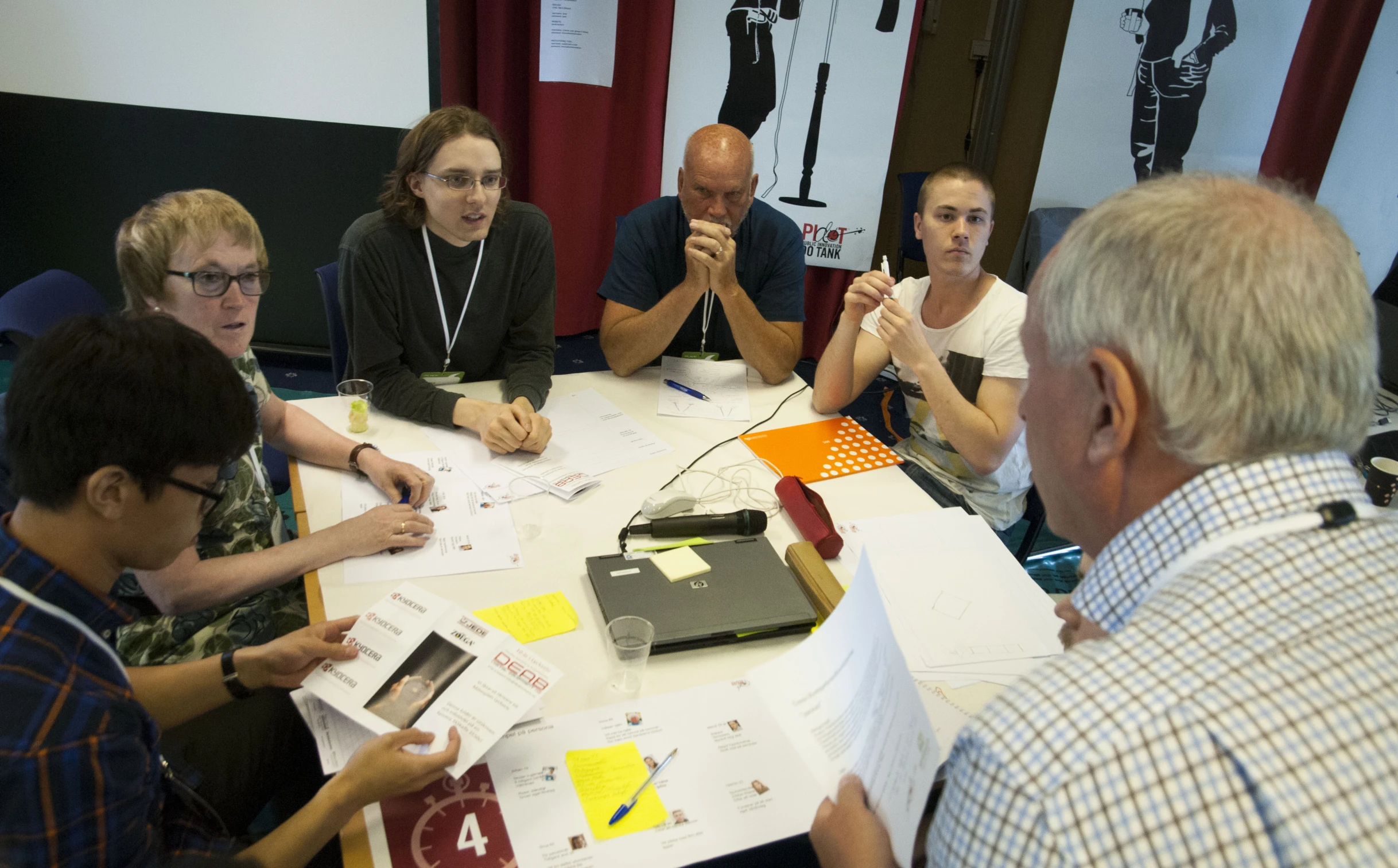 a group of people around a table working on projects