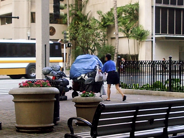 two people walking away from the bus stop with the car under their covers