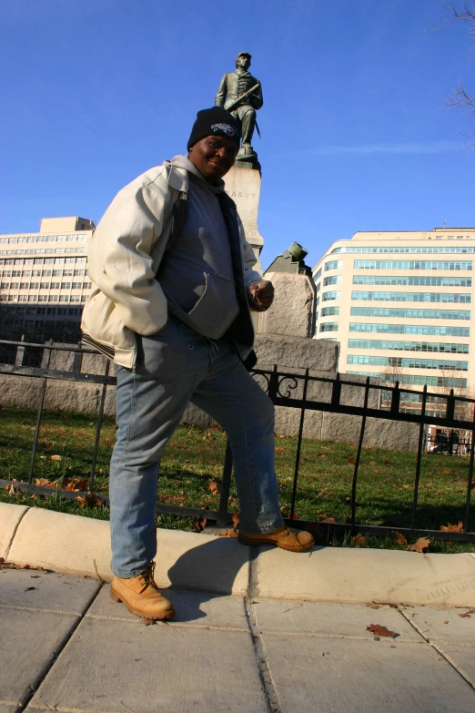 the man is posing for a po while outside on the sidewalk