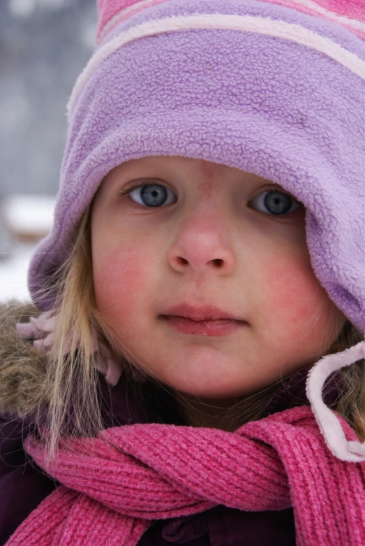 a girl in a pink hat and pink scarf