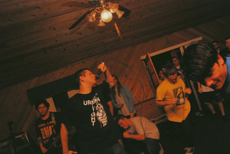 several people standing around talking and drinking in the house