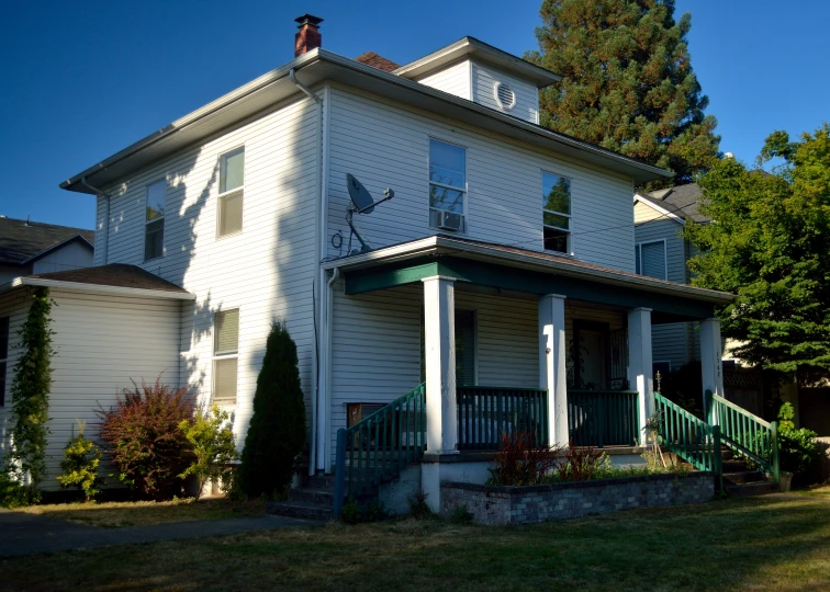 a tall white house with balconies on each level