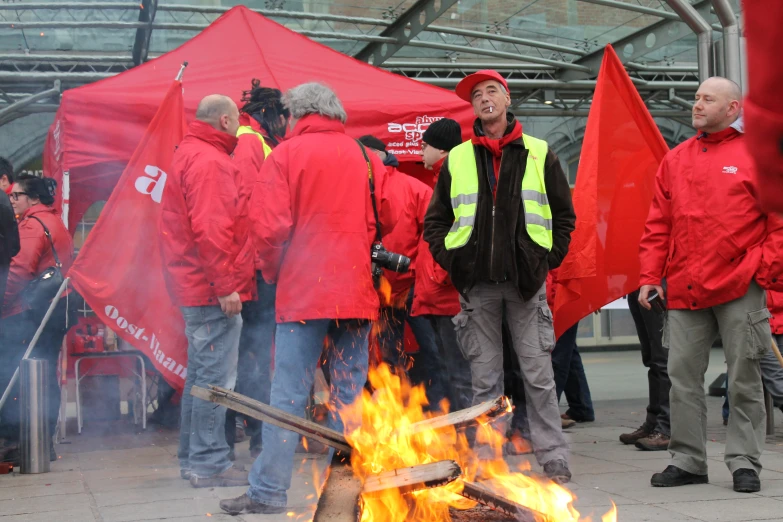 a crowd of people standing around a fire