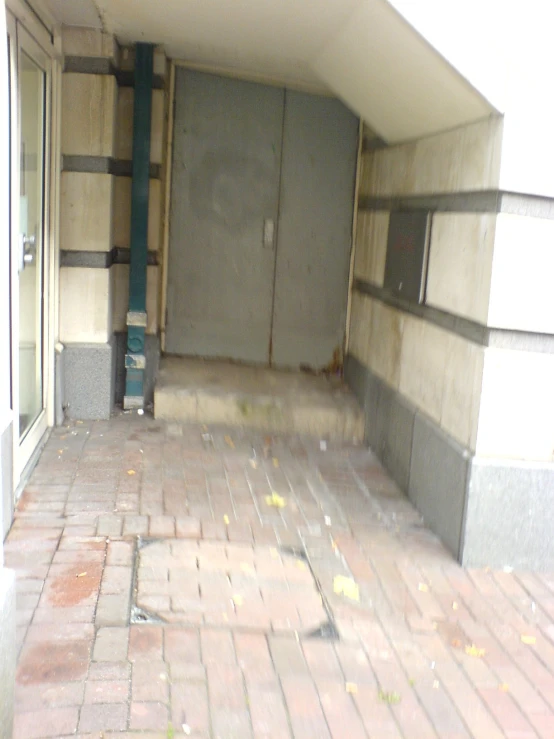 a brick sidewalk next to an entrance into a building