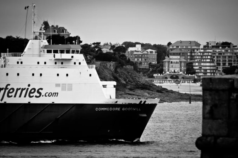 a ship traveling past a pier next to houses