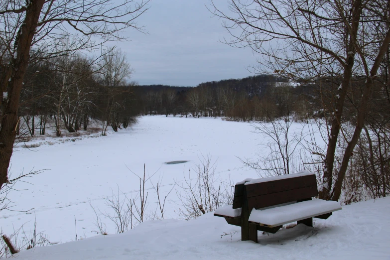 a bench on the side of the snow covered ground