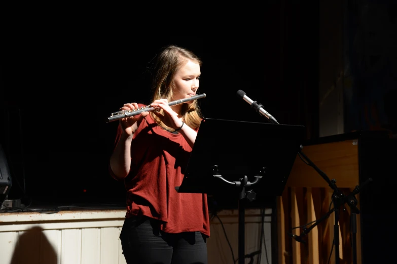 a woman playing the flute while holding an object