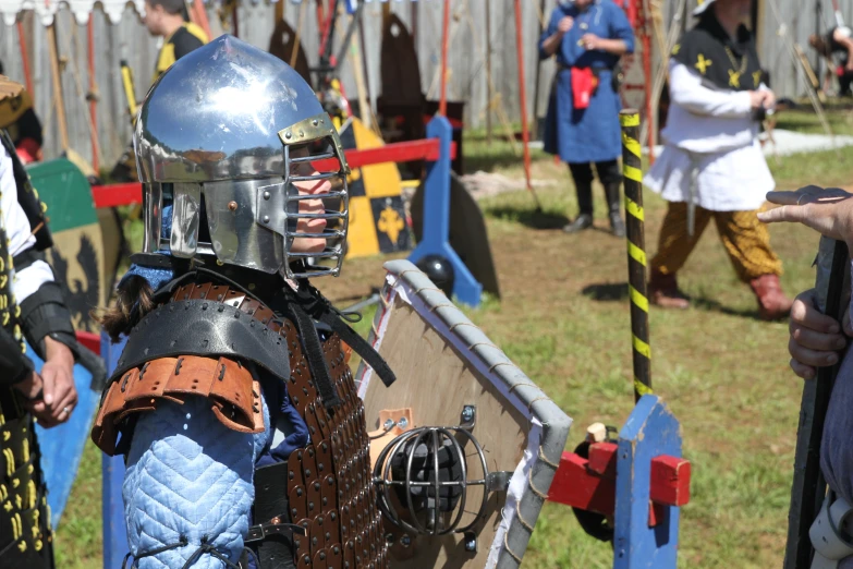 a man in a knight armor stands before a group of other people