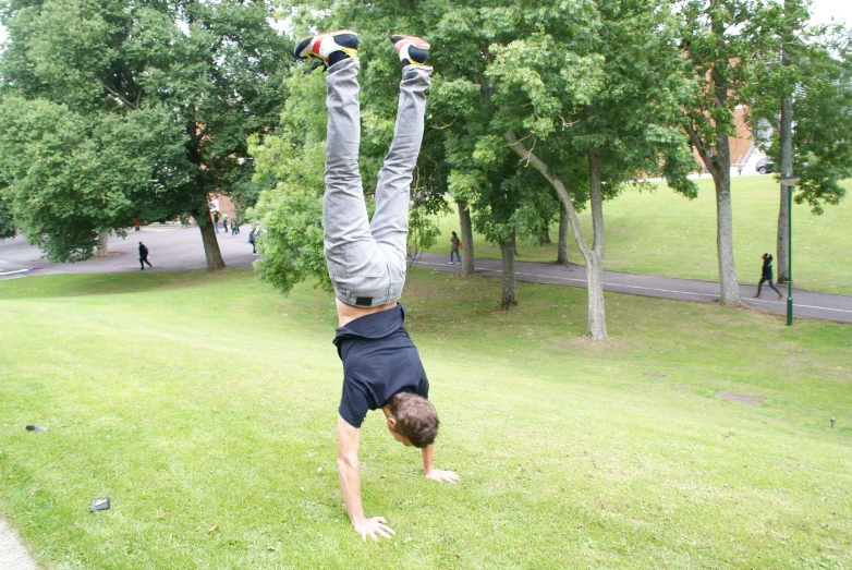 a person doing a handstand in the park