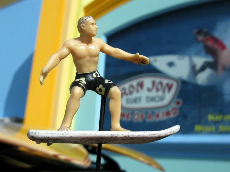 a toy surfer is posed on top of a surf board