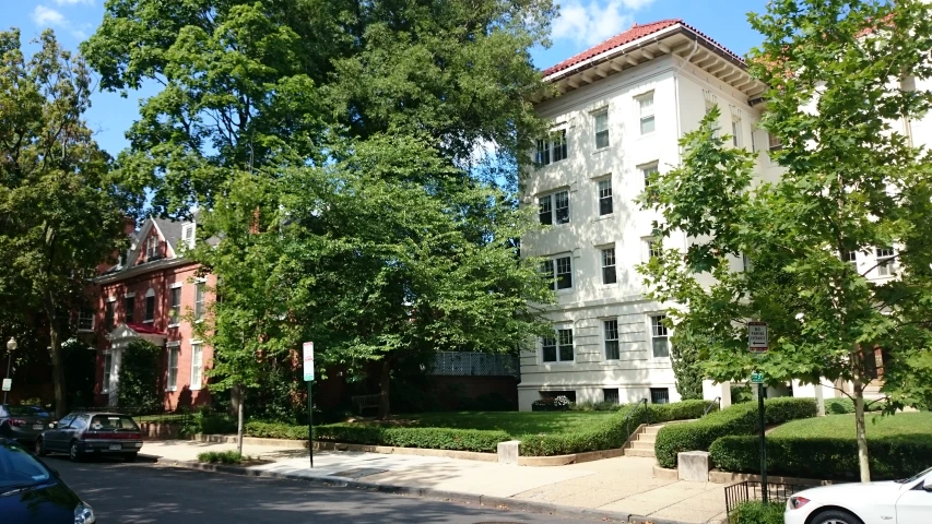 a parking lot in front of a tall white building