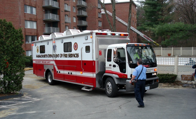 a man standing next to a white red and white fire truck