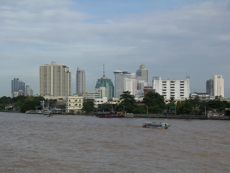 a boat in the river passing by tall buildings