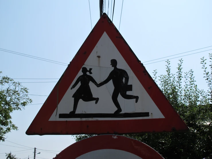 a close up of a street sign with a couple holding hands