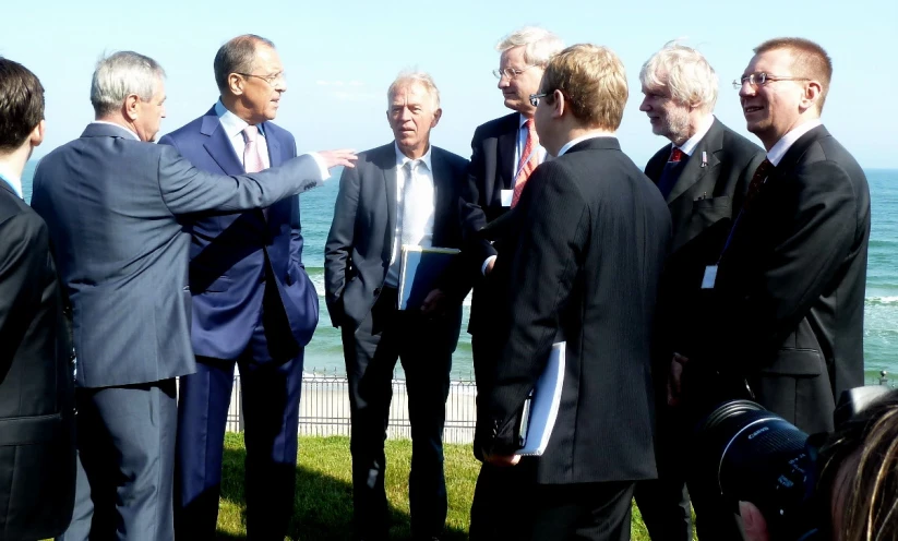 a group of businessmen gathered at the edge of a park