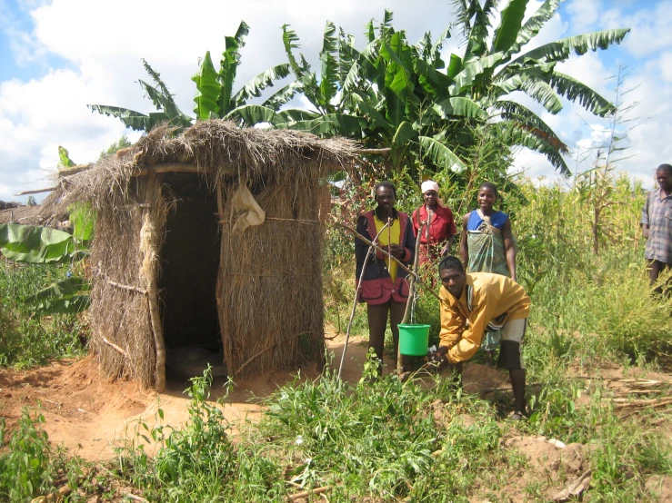 the women stand beside of their mud hut