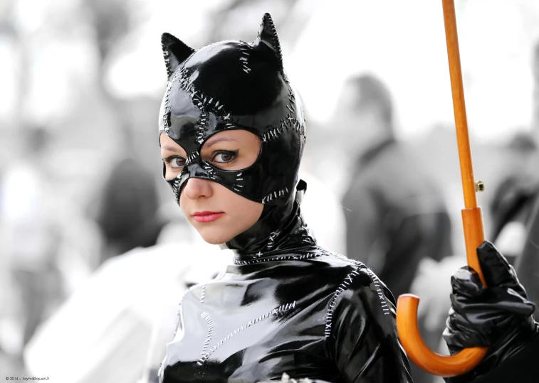 a woman in a cat costume is holding an umbrella