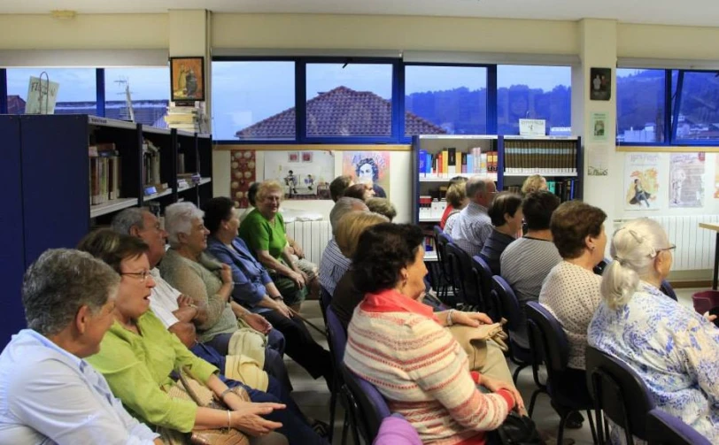 many people are sitting in chairs and one is presenting