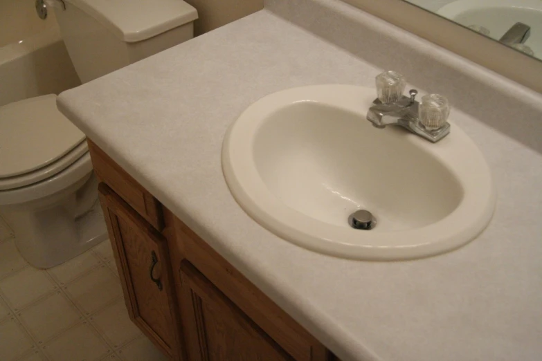 bathroom with white porcelain sink and tan tile floor