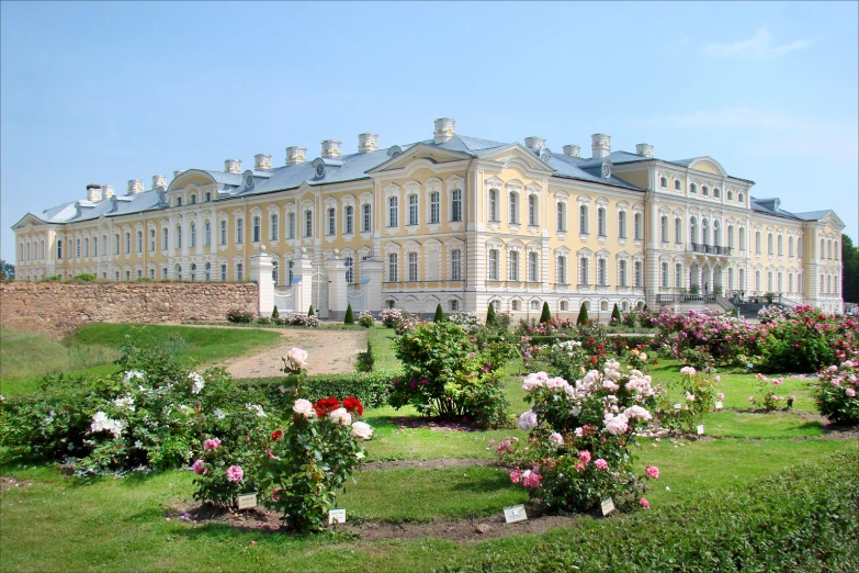 a large, beautiful old building with many flowered gardens around it