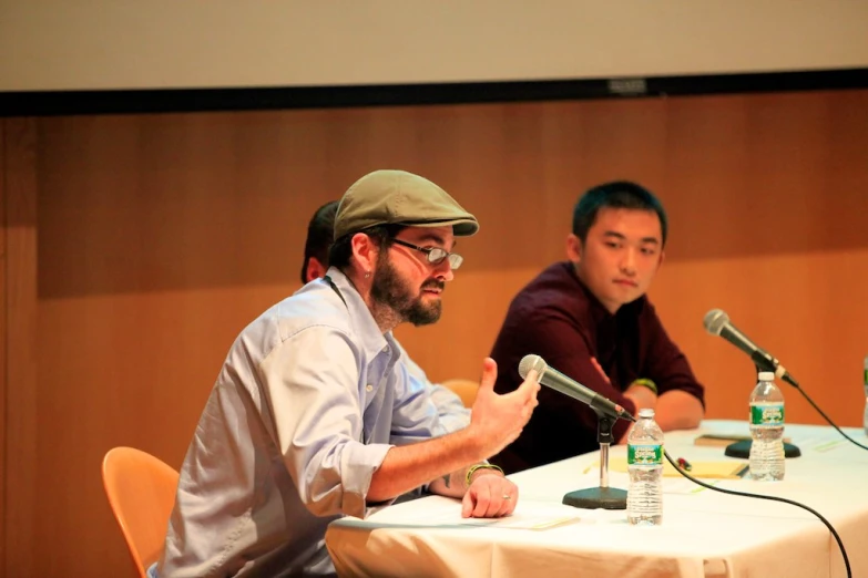 two men sitting at a table talking to each other