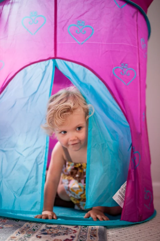 a small child in a tent on the floor