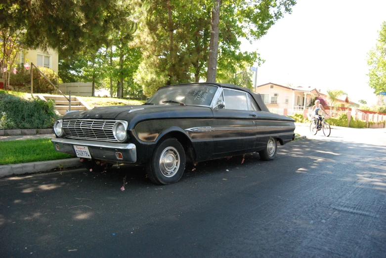 a classic car sitting on the side of the road