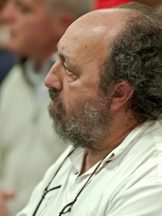 a man with curly hair looking to the side