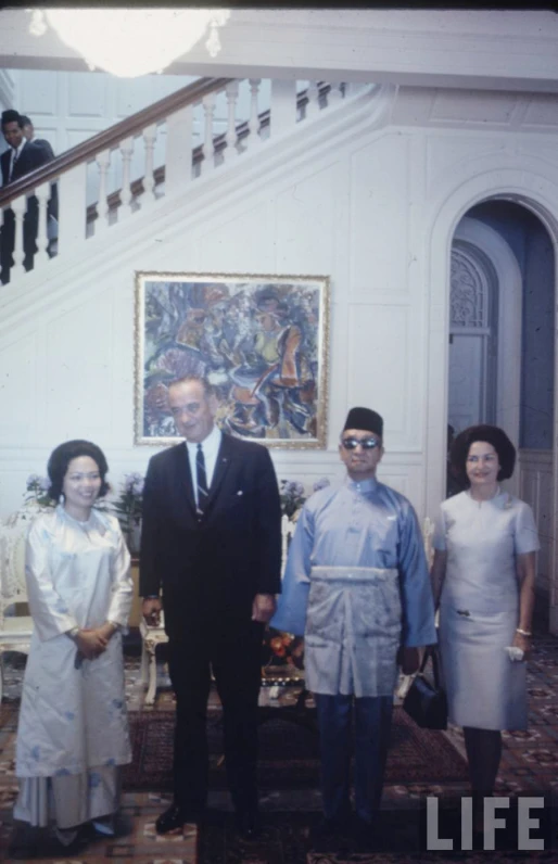 three women, one man and a child stand in the stairwell with their parents