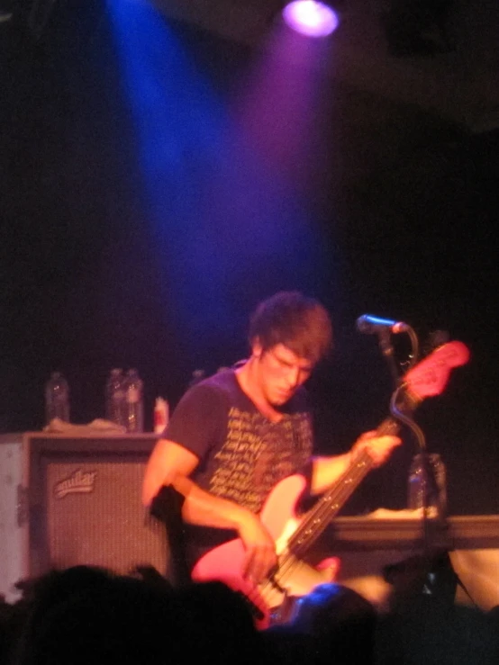 a man with glasses playing a guitar on stage