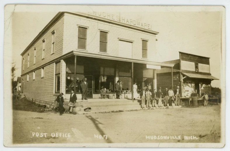 an old pograph of a group standing in front of a business