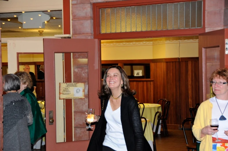 a woman holding a glass with some wine in her hand