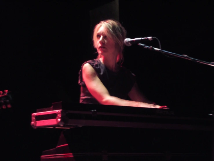 a woman playing the piano with her head bowed