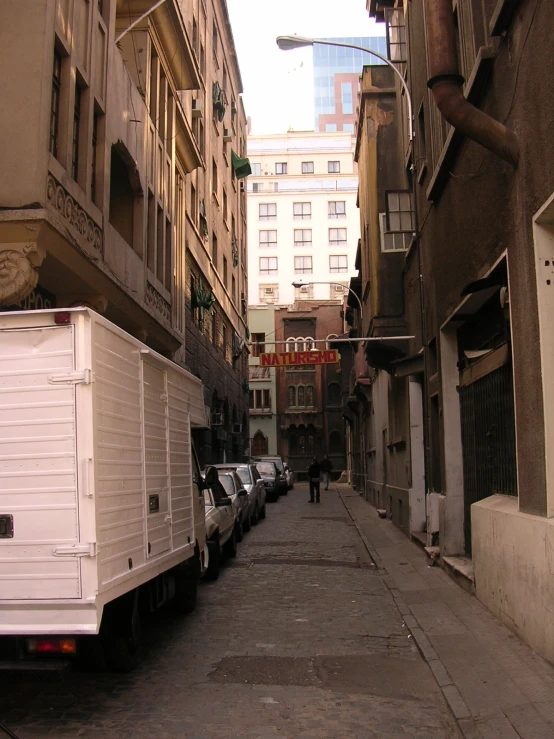 a truck and three other vehicles parked on the side of a street