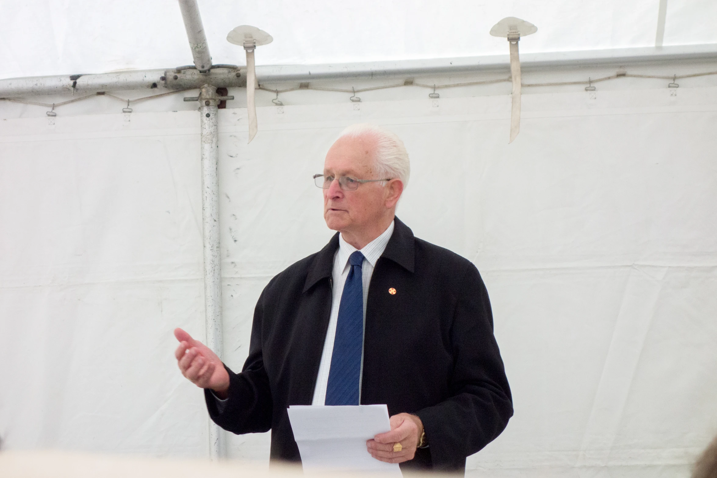 a man in a blue tie is holding soing and talking to someone