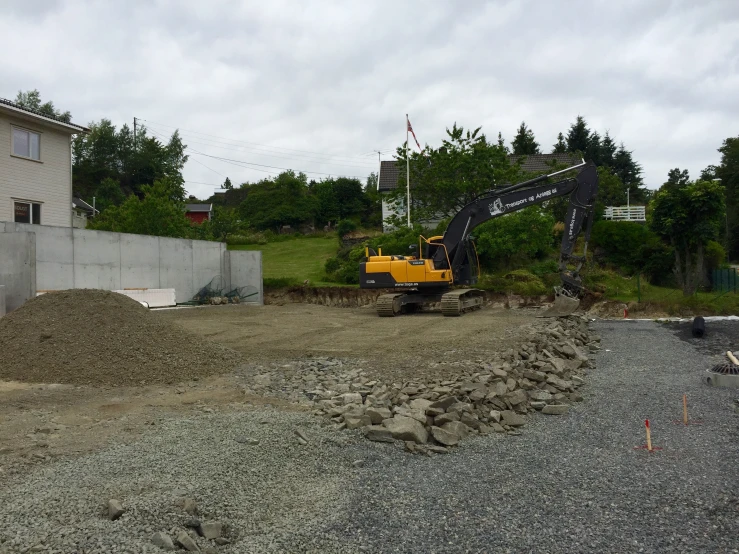 a house is being built and a large excavator is going up on the street