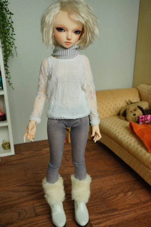 doll with blond hair and boots standing on a hardwood floor