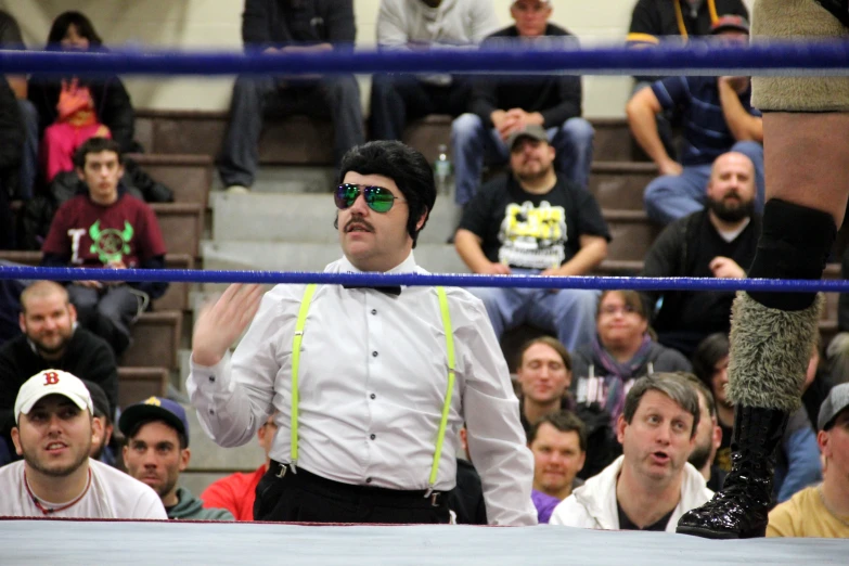 a man is standing in front of a crowd in a ring