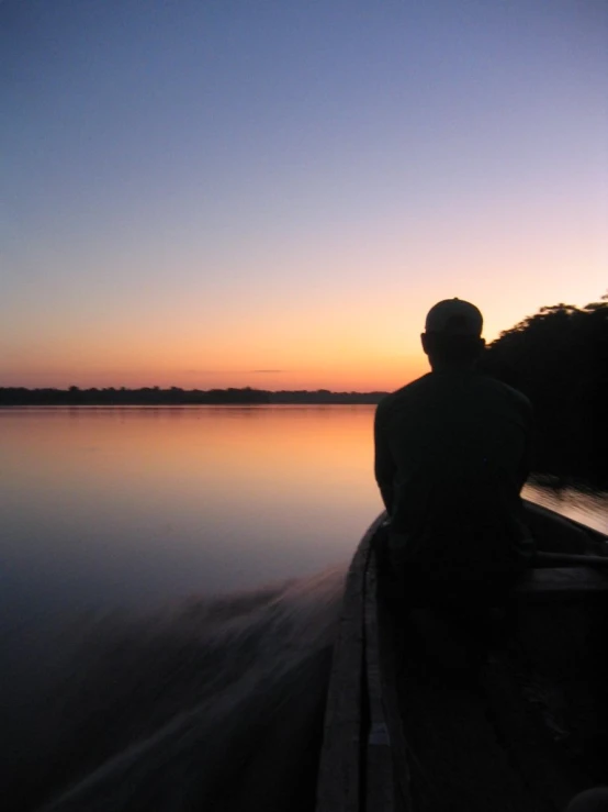 a person sitting on a pier looking out into a body of water