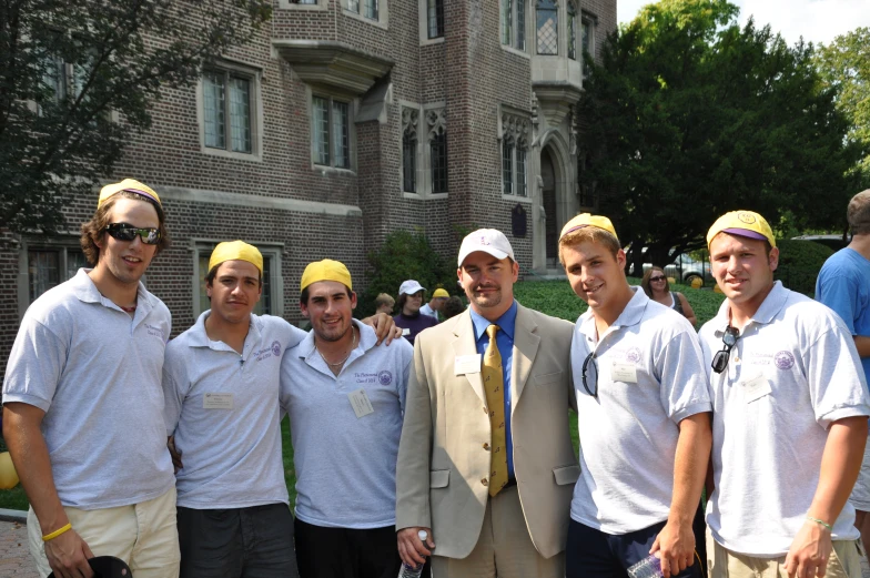 the men are posing for the picture outside on the street