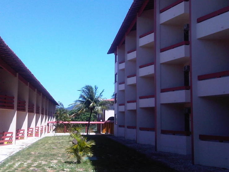 an apartment building is shown with a grassy area between two side walls