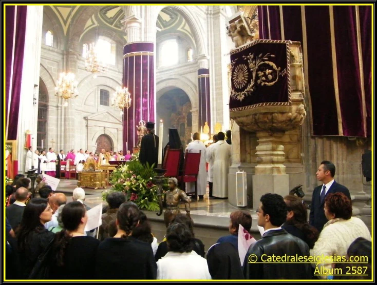 several people in black and white standing at a priest's altar