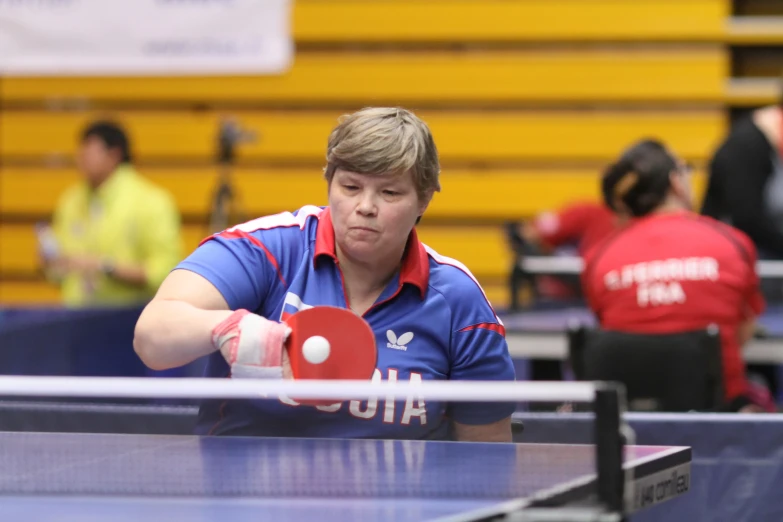 a man holding a table with red ping pong paddle