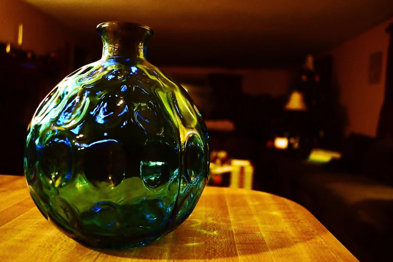 the small, green vase is sitting on a wooden table