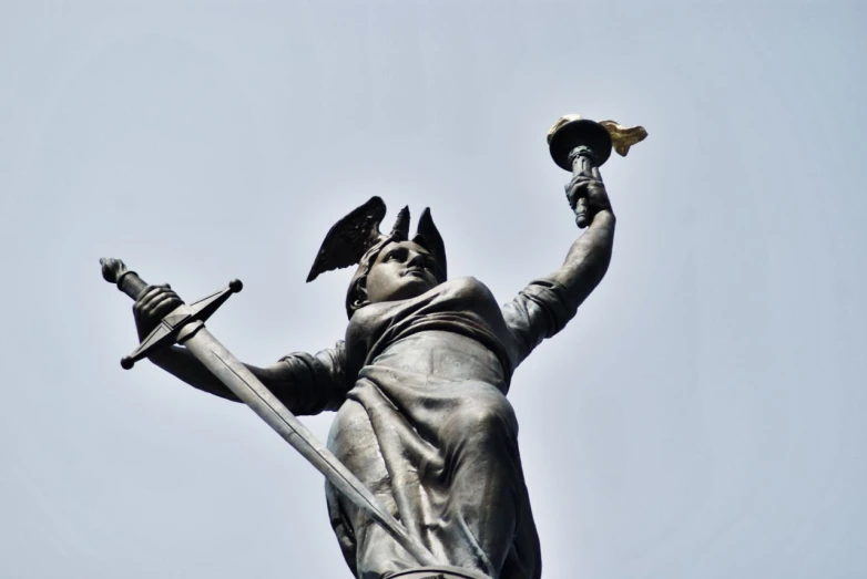 statue of a woman holding a small bird and wearing coat