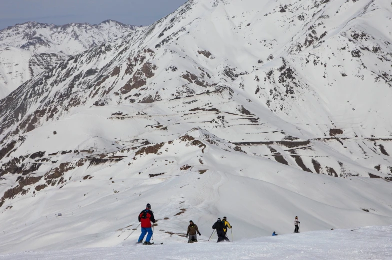 a number of people standing on top of a snow covered mountain