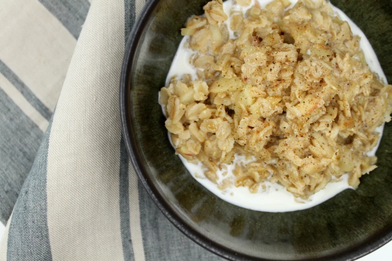 a black bowl filled with rice and cereal on a striped blanket